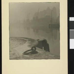 Photograph by Olaf Christoffersen of a misty morning at Oslo Harbor, featuring a mooring ring in the foreground and hazy silhouettes of cranes in the background.