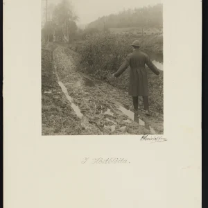 Photograph by Olaf Christoffersen of a solitary figure standing on a muddy country road in the Asker region, capturing the raw beauty and perseverance of Norway's autumn landscape.