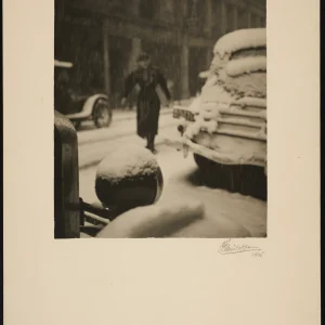 Photograph by Olaf Christoffersen from 1935 capturing a solitary figure crossing a snowy urban street, with a candid depiction of falling snow and winter’s transient silence.