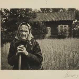 Portrait by Olaf Christoffersen of an elderly rural woman, Karen Plassen, with a weathered face and hands holding a tool, symbolizing resilience in Norwegian farming life."