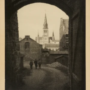 Photograph by Olaf Christoffersen from 1927 of three figures walking along the paths of Akershus Fortress beneath the shadow of Johanneskirken.