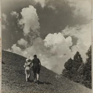 Photograph by Olaf Christoffersen of two children, Turid and Per, walking up a hillside under a dramatic sky, symbolizing hope, togetherness, and exploration.